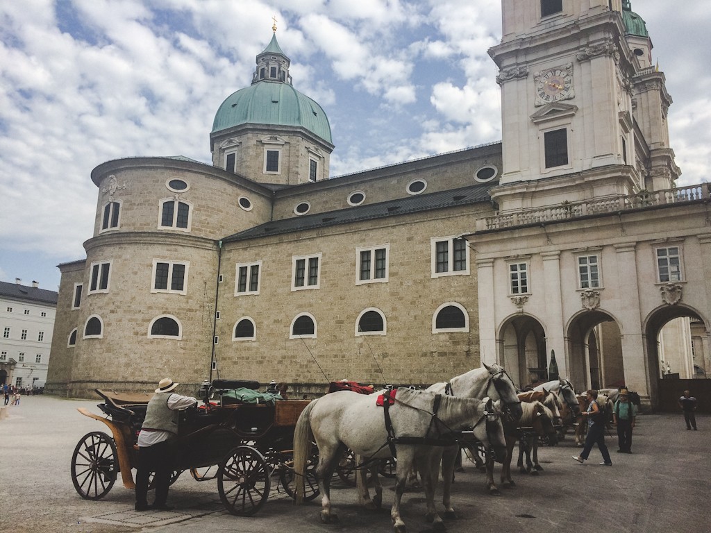 Beautiful Residenzplatz in the heart of Salzburg, with horse-drawn carriages and the Dom.